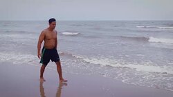 Young Asian man while performing cartwheel on the beach Stock Footage