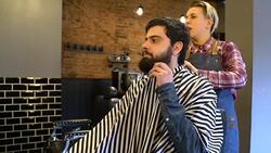Bearded man discussing with hairdresser in salon Stock Footage