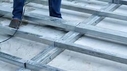 Young man working with a drill. Installation Lower base of prefabricated houses. Stock Footage