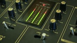 close up of dj mixer showing the volume level real time in the studio on a wooden surface Stock Footage