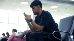 Young Asian man using mobile phone touchscreen and talking on phone. working on the phone, in the background of a Airport , planes, Concept: new business, travel, communication. Stock Footage