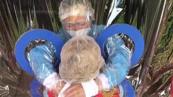 CLEAN : Salvadoran nursing home residents hug relatives through plastic curtain News Clip