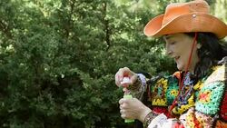 Adult stylish woman in a cowboy hat and a multicolored poncho. Stock Footage