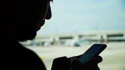 Young Asian man using mobile phone touchscreen and talking on phone. working on the phone, in the background of a Airport , planes, Concept: new business, travel, communication. Stock Footage