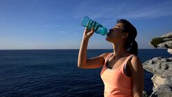 Beautiful latin american woman drinking water after exercising looking at the beautiful sunrise Stock Footage
