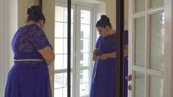 Fat girl in a blue dress in front of a mirror Stock Footage