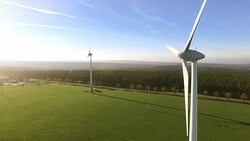 Wind turbines and agricultural fields on a summer day Stock Footage