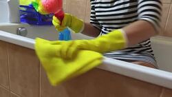 Woman with yellow rag polishing the edge of bath Stock Footage