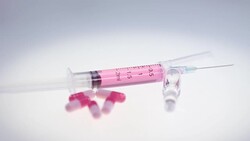 Syringe with pink liquid. Pharmaceutical pills and medical glass ampule Stock Footage