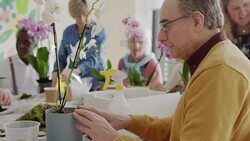 Active seniors learning to arrange orchid flowers Stock Footage