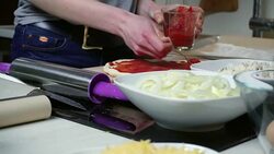 Young woman spreading tomato sauce on dough Stock Footage