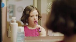 Little girl brushing her teeth in front of the mirror Stock Footage
