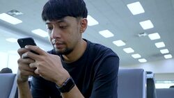 Young Asian man using mobile phone touchscreen and talking on phone. working on the phone, in the background of a Airport , planes, Concept: new business, travel, communication. Stock Footage