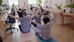Creative business people practicing yoga in open plan office Stock Footage