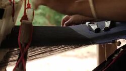 Traditional textile manufacture in craft village where old women work on wooden weaving loom machines and spin yarn creating silk or cotton fabric. Silk weaving in Thailand. Stock Footage