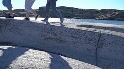 People walk among the coastal stones in Tjome nature Park, Norway Stock Footage