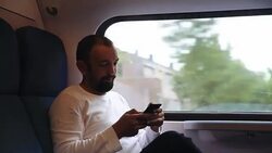 Portrait of Adult man looking at his smartphone on the train Stock Footage