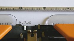 Close up footage of an old typewriter and a person writing NUCLEAR WAR on it Stock Footage