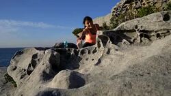 Beautiful woman exercising outdoors stretching looking very happy near the sea Stock Footage