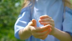 Little girl in blooming apple tree garden on spring day plays with ladybug Stock Footage