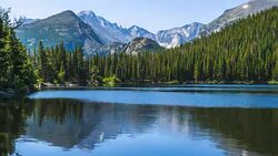 Bear Lake - Time-lapse video of gusty winds stirring up calm Bear Lake on a sunny Summer morning, with rugged Longs Peak and Glacier Gorge towering in background, Rocky Mountain National Park, CO, USA. Stock Footage
