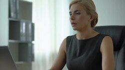 Overweary businesswoman sitting at office desk, irregular working hours, stress Stock Footage