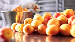 hands pastry chef cutting apricots, prepare the jam in industrial kitchen worktop Stock Footage