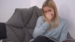 Beautiful girl thumbs a magazine in the chair Stock Footage