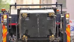 Garbage truck drives collecting garbage in slow motion Stock Footage