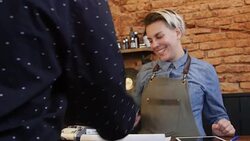 Female barber using credit card reader at counter Stock Footage