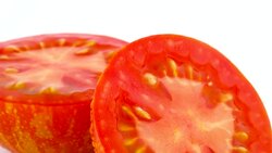 Macro shooting. Cross section of red globe striped tomato. Two halves. Slowly rotating on the turntable isolated on the white background. Close-up. Macro. Stock Footage