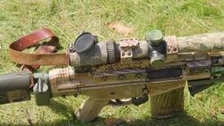 The brown camouflage color of the sniper on the ground Stock Footage