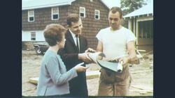 1960s: A man, woman, and worker are at a home construction site Stock Footage