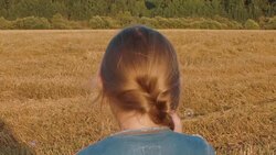 Girl blowing soap bubbles on farming field background, back view Stock Footage