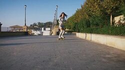Young stylish attractive woman skateboarding at sunrise on seafront, slow motion Stock Footage
