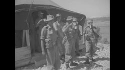 During Korean War, Indian soldiers who will take care of North Korean and Chinese Communist POWs stand in front of tent drinking beverages News Clip