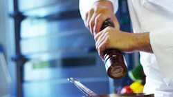 in an Italian professional kitchen a chef pours salt on a dish or in the water to boil the Italian pasta concept of healthy and light food. Stock Footage