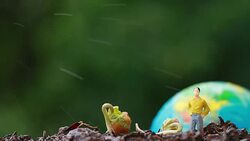 Miniature people yellow suit standing near young plants seeding growing on fertile soil with blur globe model for agriculture in garden. Agriculture for learning and save green world concept. Stock Footage