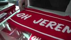 Shot of a red 'Oh Jeremy Corbyn!' scarf being unfurled on a table at the Labour Party conference in Liverpool Stock Footage