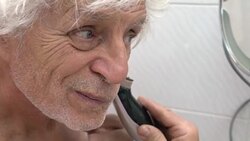 Senior man shaves off his beard Stock Footage