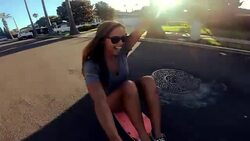 POV happy girl skateboarding down street at sunset holding selfie camera Stock Footage