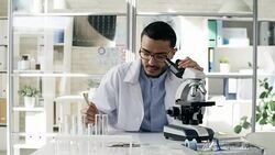 Focused Black Scientist Using Microscope Stock Footage