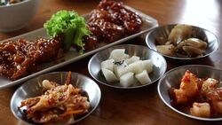 Eating Korean spicy sauce fried chicken with side dishes 4k Stock Footage