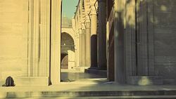 WIDE ANGLE OF INTERIOR STONE COURTYARD. PILLARS OR COLUMNS. STRIPED POINTED ARCHES. ISLAMIC ARCHITECTURE. SULEYMANIYE MOSQUE. DOME VISIBLE IN BG. POV THROUGH ENTRANCE. Stock Footage