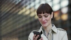 Businesswoman reading text message and laughing Stock Footage