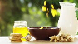 on a sunny day in the garden pours cereals in a cup where the cereals falls in slow motion . concept of healthy food and breakfast of milk and bisquits or cookies and cereals. bio food Stock Footage