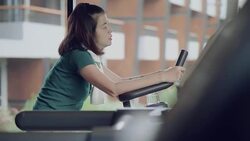 Beautiful woman cycling on the exercise bike in the gym Stock Footage