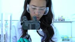 Scientist is looking through microscope with colleagues working in modern laboratory or medical center together. Concept of science, testing development and lab industry. Stock Footage