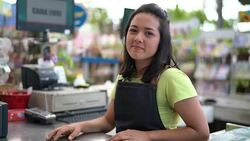 Portrait of confident owner leaning on checkout counter at flower shop Stock Footage