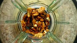 Crushing of walnut in the blender. Slow motion.	Knives crush walnut. Top view. Stock Footage